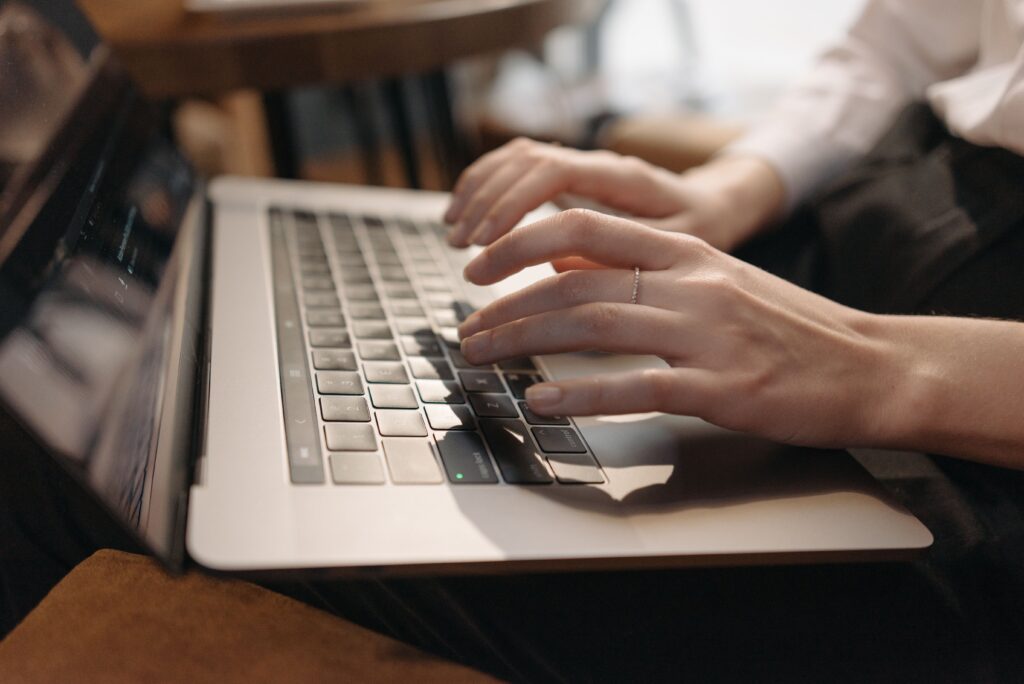Persona escribiendo en su laptop mientras trabaja en el contenido de su negocio