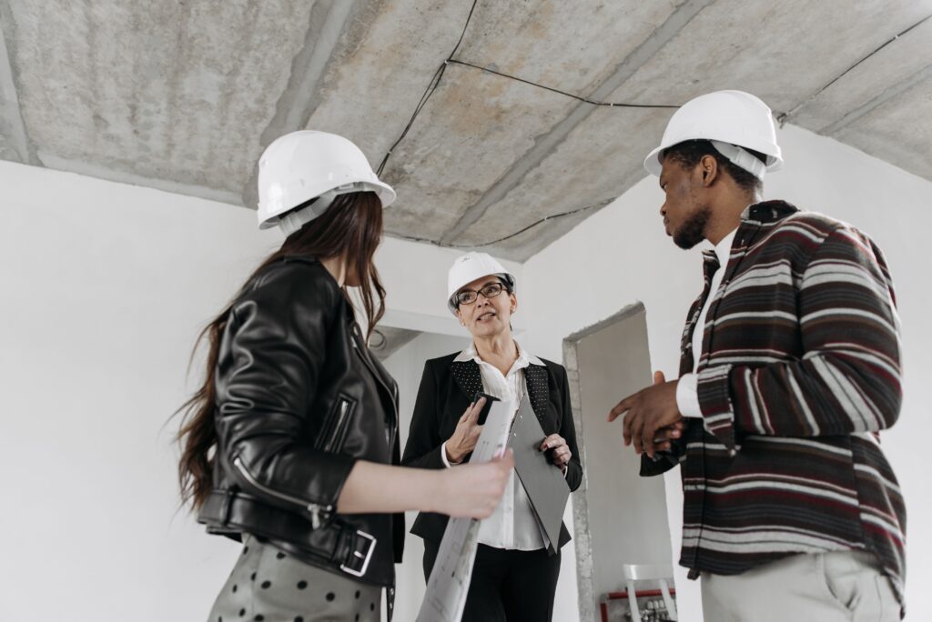 Contratista explicando un proyecto de construcción a sus clientes en obra