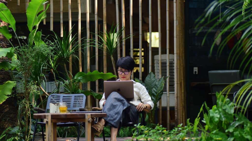 Mujer trabajando en su negocio desde la laptop en un espacio al aire libre