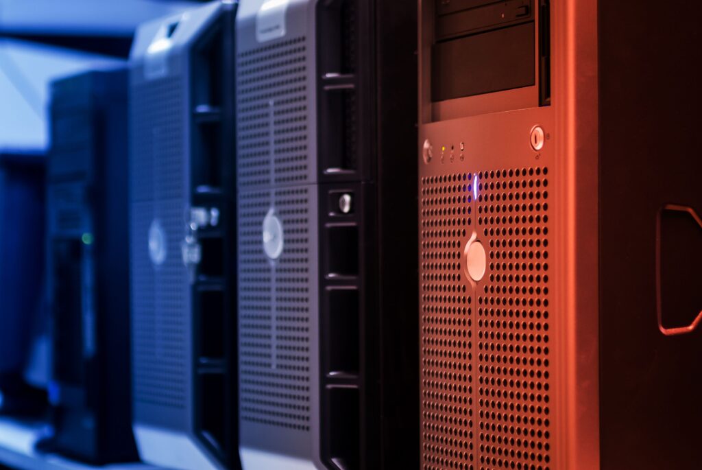 Rack de servidores en un data center con iluminación azul y naranja, representando el hosting web que aloja un sitio