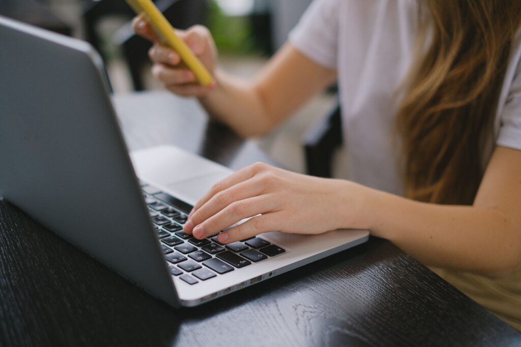 Persona escribiendo en su laptop mientras redacta un newsletter